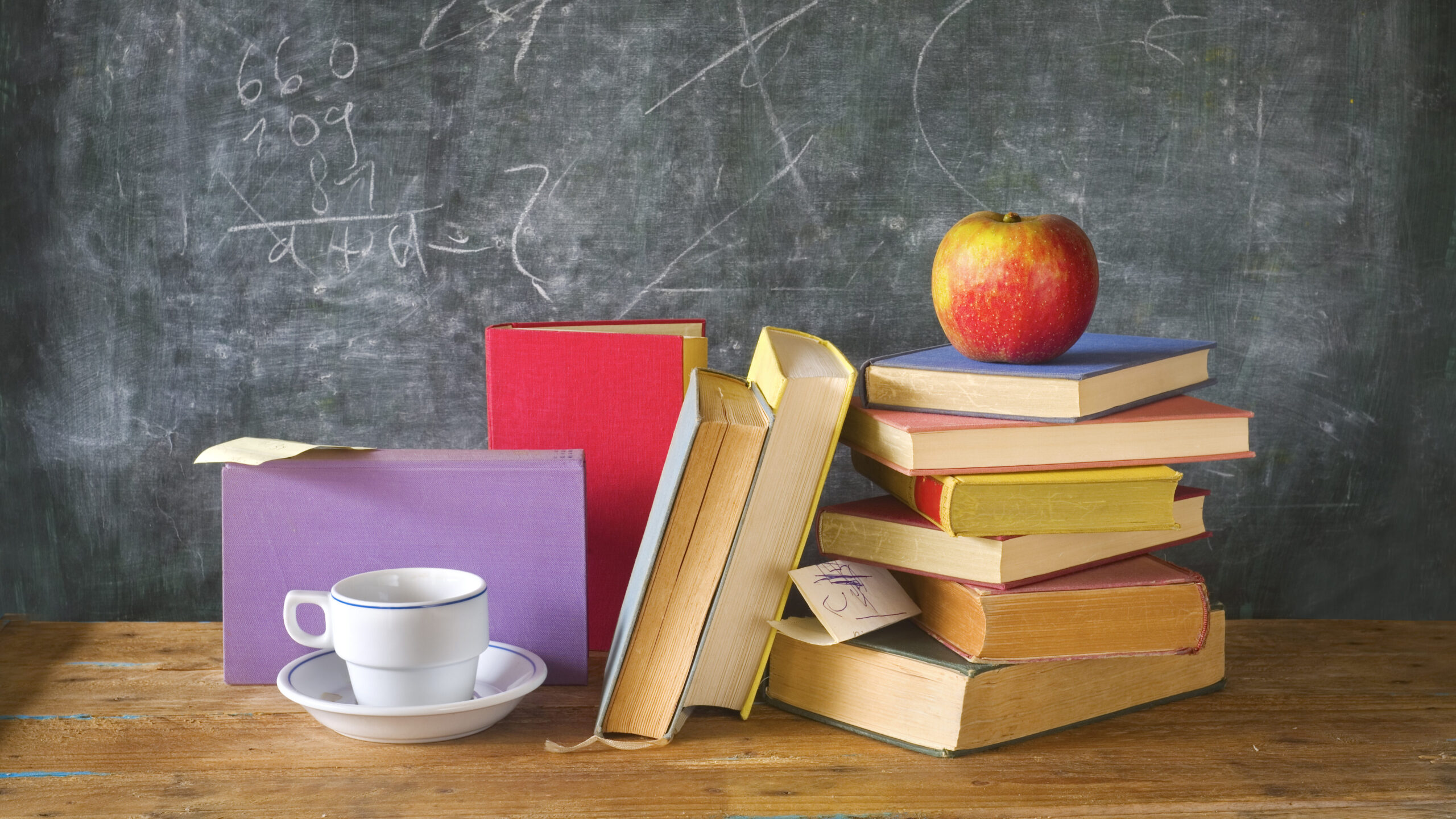stacks of books, cup of coffee, apple, black board, education, learning concept